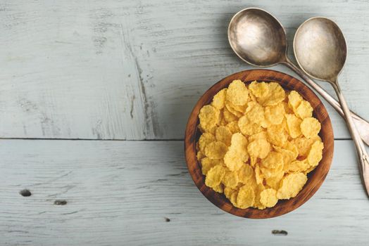 Rustic bowl of corn flakes over wooden surface. View from above