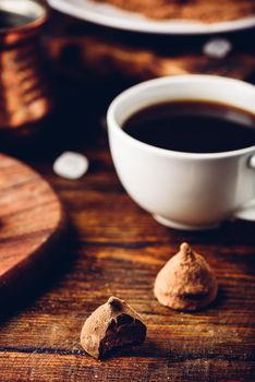 Homemade chocolate truffles coated in cocoa powder with black coffee