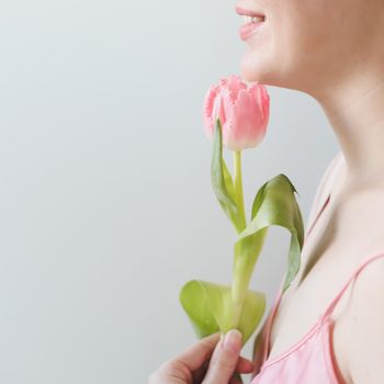 romantic tender portrait of a young woman with pink fresh tulips