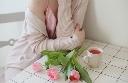 romantic tender portrait of a young woman with pink fresh tulips