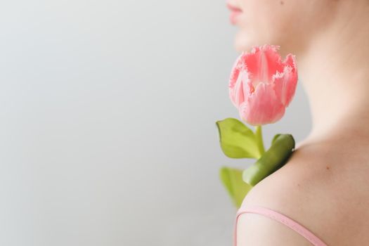 romantic tender portrait of a young woman with pink fresh tulips