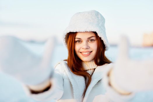 beautiful woman in a white coat in a hat winter landscape walk Fresh air. High quality photo