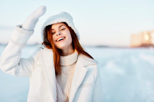 woman in a white coat in a hat winter landscape walk Fresh air. High quality photo