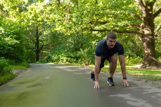 A man athlete runs in the park outdoors, around the forest, oak trees green grass young enduring athletic athlete healthy exercise, workout trail recreation motion, jogging wellbeing. running, morning stretches