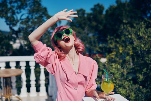 cheerful woman in green sunglasses with cocktail in summer outdoors Drinking alcohol. High quality photo