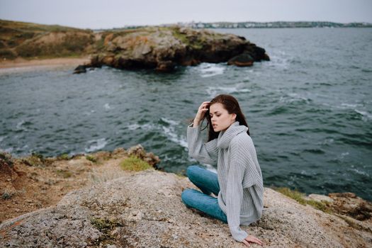 beautiful woman beach tourism cloudy weather stone coast Relaxation concept. High quality photo