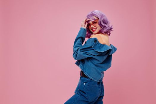 Portrait of a charming lady purple hair fashion glasses denim clothing pink background unaltered. High quality photo