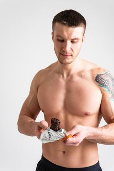 Man eats protein bar on white background isolated protein eat, man background white person, energetic workout. break smile female