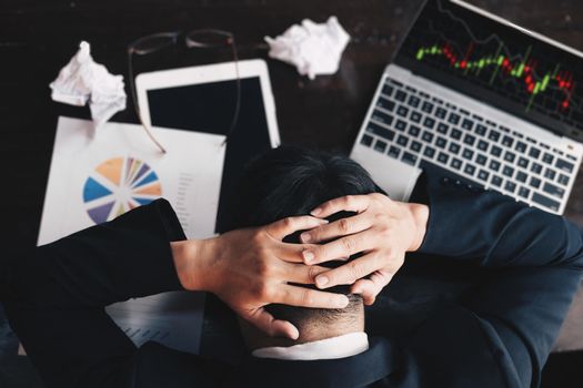 Stock market concept, business man looking at stock market graph on computer screen is showing disappointment after buying stocks but not profiting from investment as expected, High risk investment