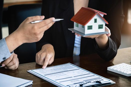 Loan signing concept, refinancing, home and land purchase, rental accommodation, female real estate agent or bank employee pointing to a contract or agreement with a male client to to Buy a dwelling