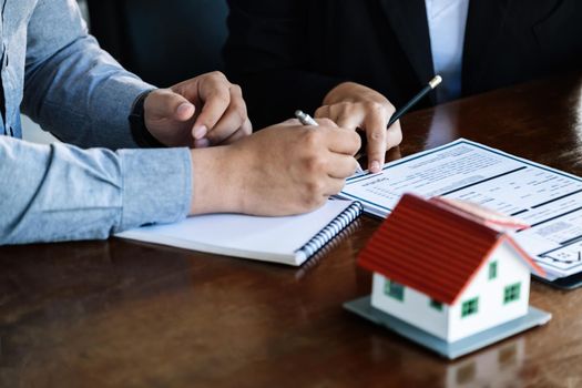 Loan signing concept, refinancing, home and land purchase, rental accommodation, female real estate agent or bank employee pointing to a contract or agreement with a male client to to Buy a dwelling