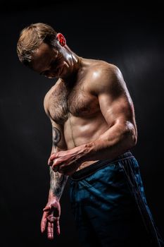 Man on black background keeps dumbbells pumped up in fitness bodybuilding biceps torso, athlete workout lifting powerful, pectoral. Attractive skin human fit View from the bottom up good press beautiful muscles hairy chest charisma