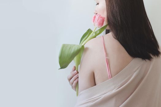 romantic tender portrait of a young woman with pink fresh tulips