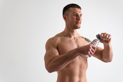 Male drink-water fitness is pumped with a towel on a white background isolated strong health, drink exercise male nutrition person, background Bodybuilding active, sportsman one muscle