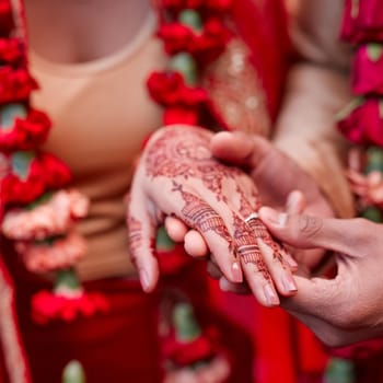Cropped shot of a hindu couple exchanging rings on their wedding day.