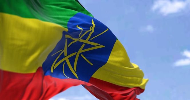 Detail of the national flag of Ethiopia waving in the wind on a clear day. Ethiopian is a landlocked country in the Horn of Africa. Selective focus.