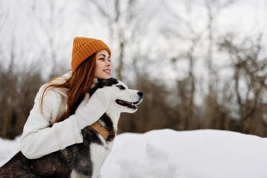 portrait of a woman winter clothes walking the dog in the snow winter holidays. High quality photo