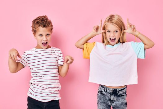 boy and girl fun antics pink background. High quality photo