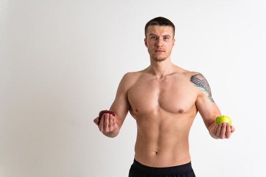 Man holds apples in fitness white background isolated apple isolated body, handsome fruit strong caucasian studio. Hand hold holding chest
