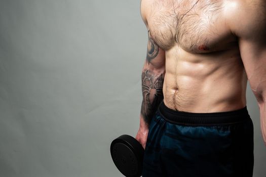 Man on black background keeps dumbbells pumped up in fitness muscle torso, athlete strong bodybuilder heavy, male pectoral. handsome power, gym fit beautiful press with hair dumbbells and body press beautiful