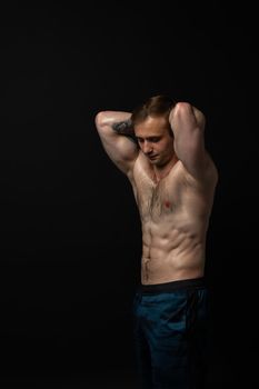 Man on black background keeps dumbbells pumped up in fitness muscle biceps sport, athlete muscular strong athletic heavy, shirtless handsome adult, people fit hands behind your head a beautiful press