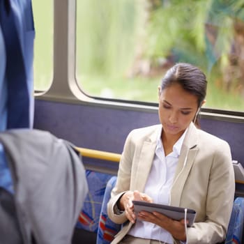 Shot of a businesswoman using a digital tablet while commuting on a bus.