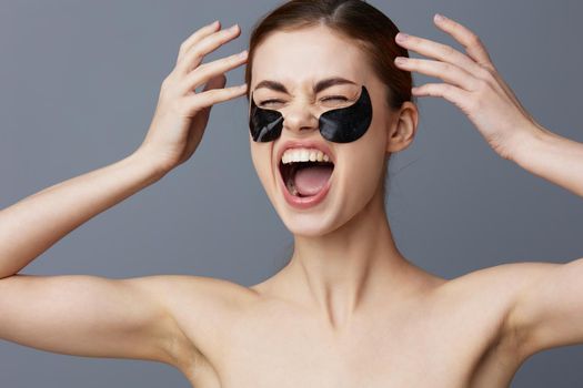 woman eye patches on face bare shoulders skin care close-up Lifestyle. High quality photo