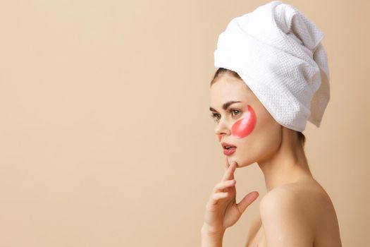 portrait woman pink patches on the face with a towel on the head beige background. High quality photo