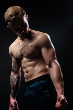 Man on black background keeps dumbbells pumped up in fitness muscle black, arm training man hold dumbbell, person lifestyle. Young sportive adult, guy fit View from the bottom up good press beautiful muscles hairy chest charisma