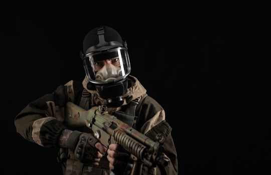 man in a military uniform and a gas mask holds a weapon with an angry expression of emotion