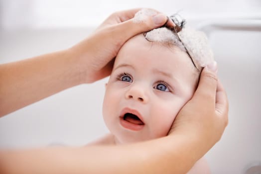 Cropped shot of a mother washing her baby boys hair.
