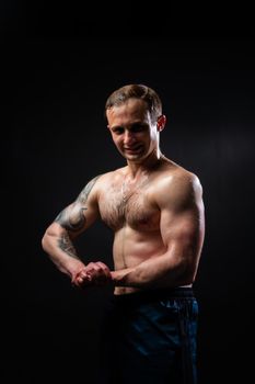 Man on black background keeps dumbbells pumped up in fitness muscle torso, weight man athletic powerful, pectoral. Young metal, gym fit View from the bottom up good press beautiful muscles hairy chest charisma