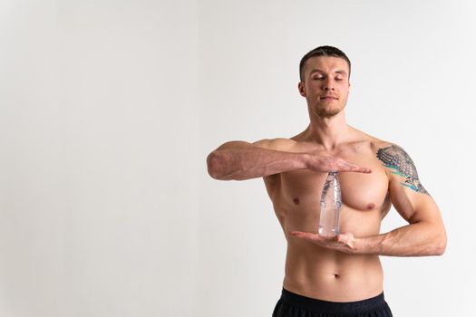 Male drink-water fitness is pumped with a towel on a white background isolated athlete body, sport energy man holding, athletic. Strength pace, powerful one muscle