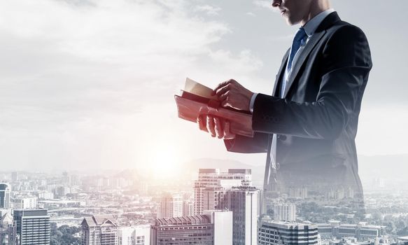 Double exposure of elegant businessman with diary in hands looking away