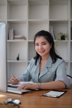 Asian business woman having video call with business team to consult about business plan of company. Online team meeting video conference