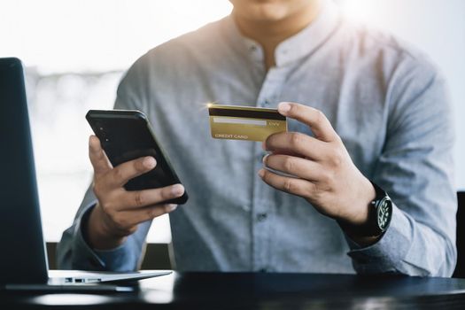 Online Shopping and Internet Payments, Asian man are using their credit card and mobile phone to shop online or conduct errands in the digital world