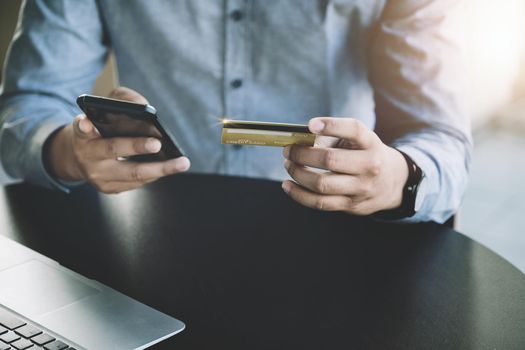 Online Shopping and Internet Payments, Asian man are using their credit card and mobile phone to shop online or conduct errands in the digital world