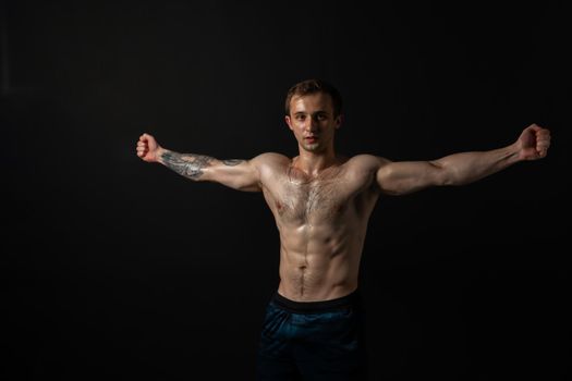 Man on black background keeps dumbbells pumped up in fitness bodybuilding muscular workout hold hand, male pectoral. Young sportive adult, one fit