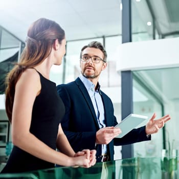 Cropped shot of two businesspeople talking in the office.