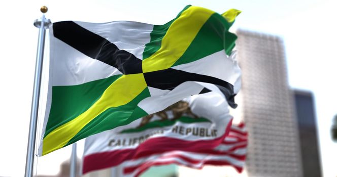 Monterey city flag waving in the wind with California state and United States national flags blurred in background. San Diego municipal flag