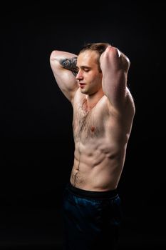 Man on black background keeps dumbbells pumped up in fitness active sexy sport, athlete weight dumbbell, weightlifting. sportive adult, human fit hands behind your head a beautiful press