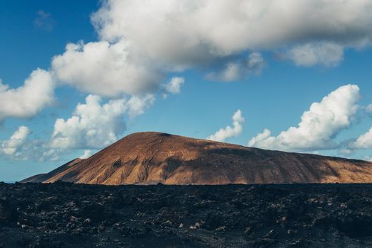 Amazing panoramic landscape of volcano craters in Timanfaya national park. Popular touristic attraction in Lanzarote island, Canary islans, Spain. Artistic picture. Beauty world. Travel concept