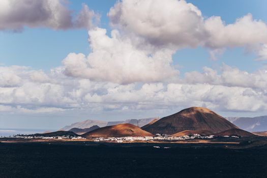 Amazing panoramic landscape of volcano craters in Timanfaya national park. Popular touristic attraction in Lanzarote island, Canary islans, Spain. Artistic picture. Beauty world. Travel concept