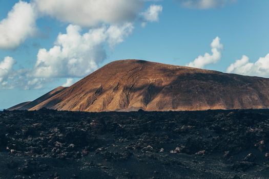 Amazing panoramic landscape of volcano craters in Timanfaya national park. Popular touristic attraction in Lanzarote island, Canary islans, Spain. Artistic picture. Beauty world. Travel concept