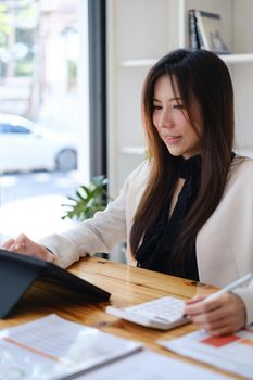 Asian accountant woman working audit budget and finance of company on wooden desk in office. consult, business, tax concept