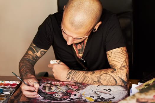 A young man drawing a tattoo design.