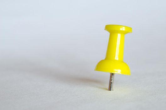 Yellow push pin. Closeup photography of yellow thumbtack.