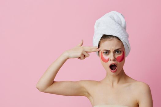 young woman pink patches on the face with a towel on the head close-up Lifestyle. High quality photo