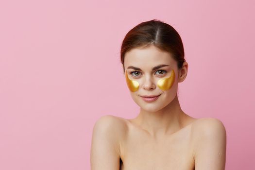 portrait woman golden patches on the face pink background. High quality photo