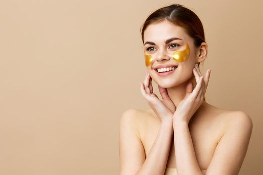 young woman golden patches clean skin smile posing beige background. High quality photo